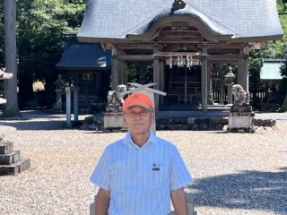 久保和平・実行委員長が山国神社本殿をバックに
